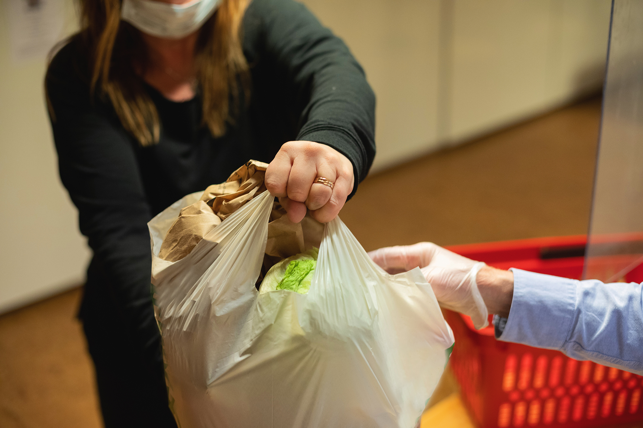 En person överräcker en matkasse till en annan person