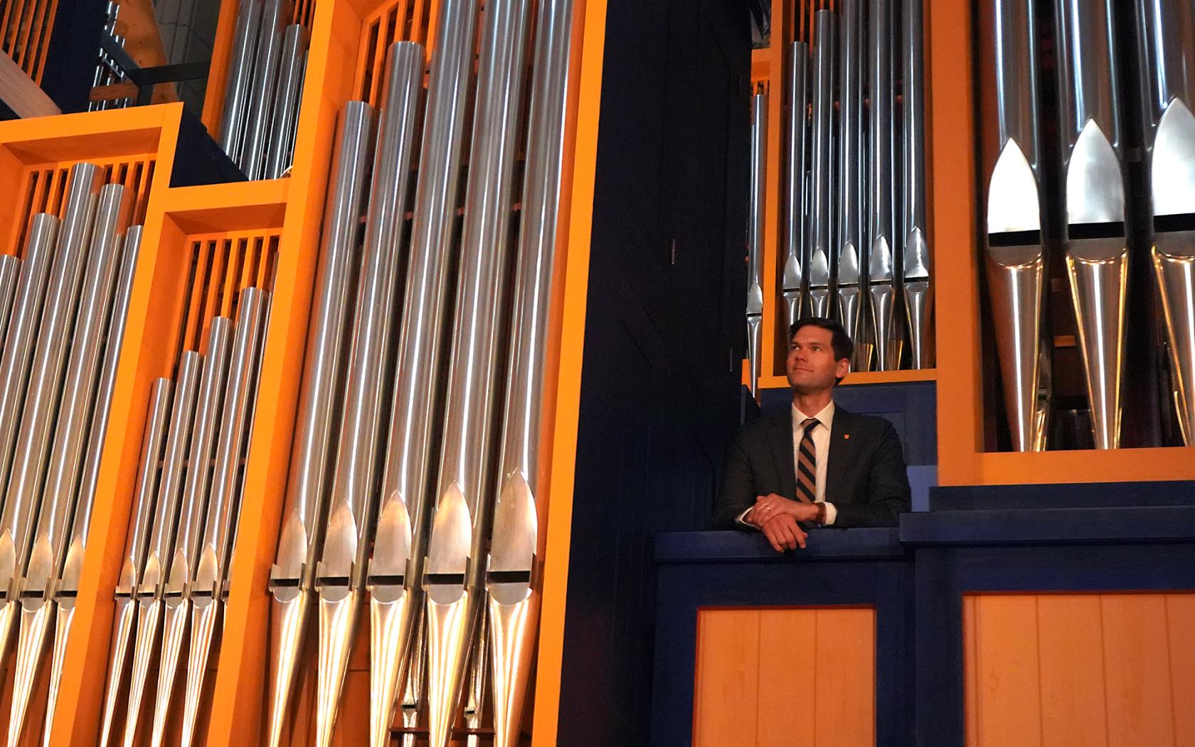 Robert Bennesh, organist, står uppe bland Ruffattiorgelns stora och små pipor och blickar ut över Uppsala domkyrka.