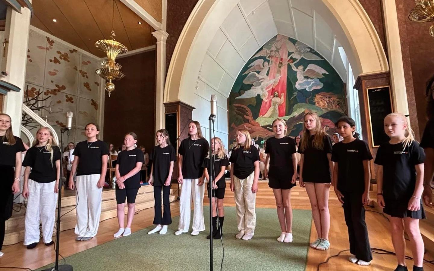 Barn som står på rad och sjunger i kyrkan