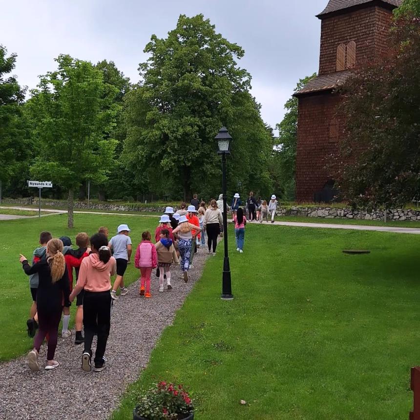 Ett led av barn som promenerar mot Nysunds kyrka