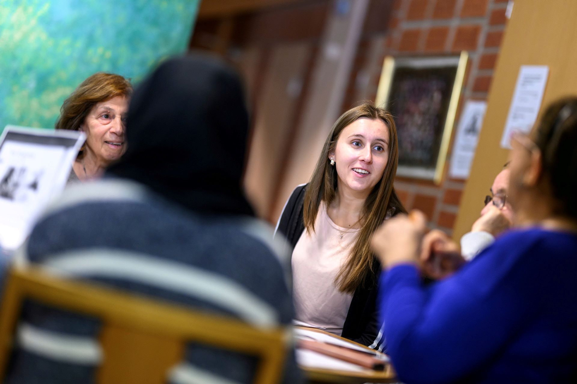 Några personer sitter och diskuterar glatt runt ett bord