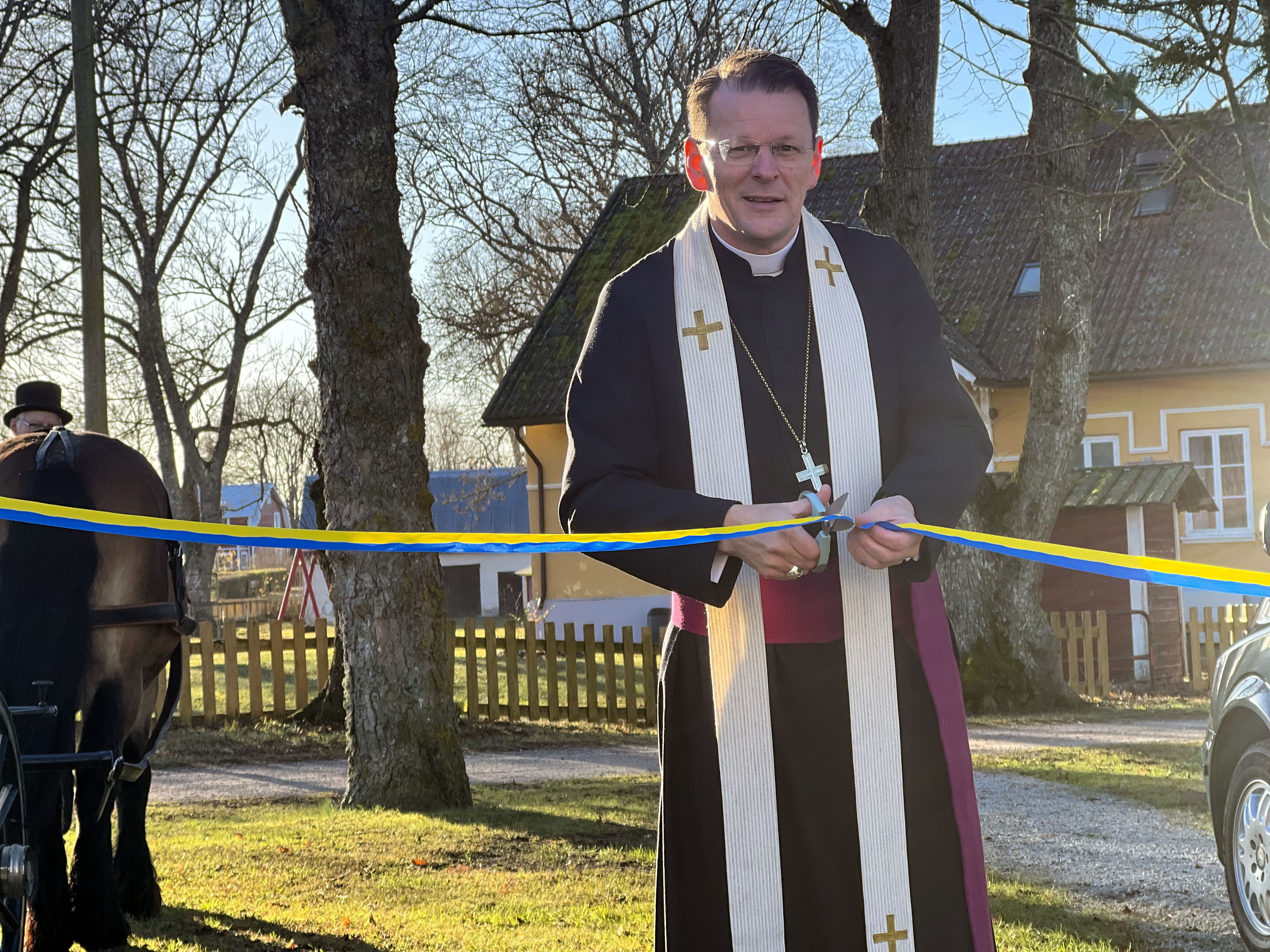 Biskop Erik klipper bandet vid invigningen av Kyrkans Begravningsbyrå i Romaklosters pastorat