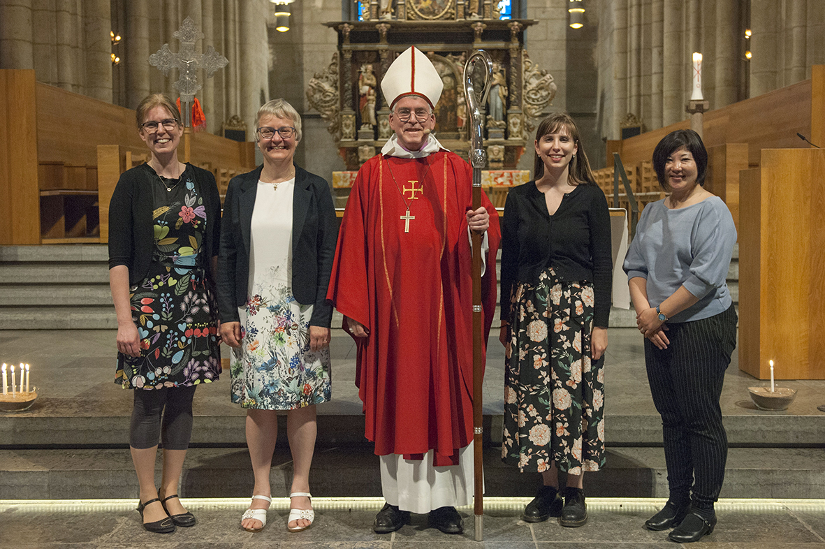 Ulrica, Berit, biskop Åke, Gabriella och Kanako står i koret i Skara domkyrka med pelare och altare i bakgrunden. 