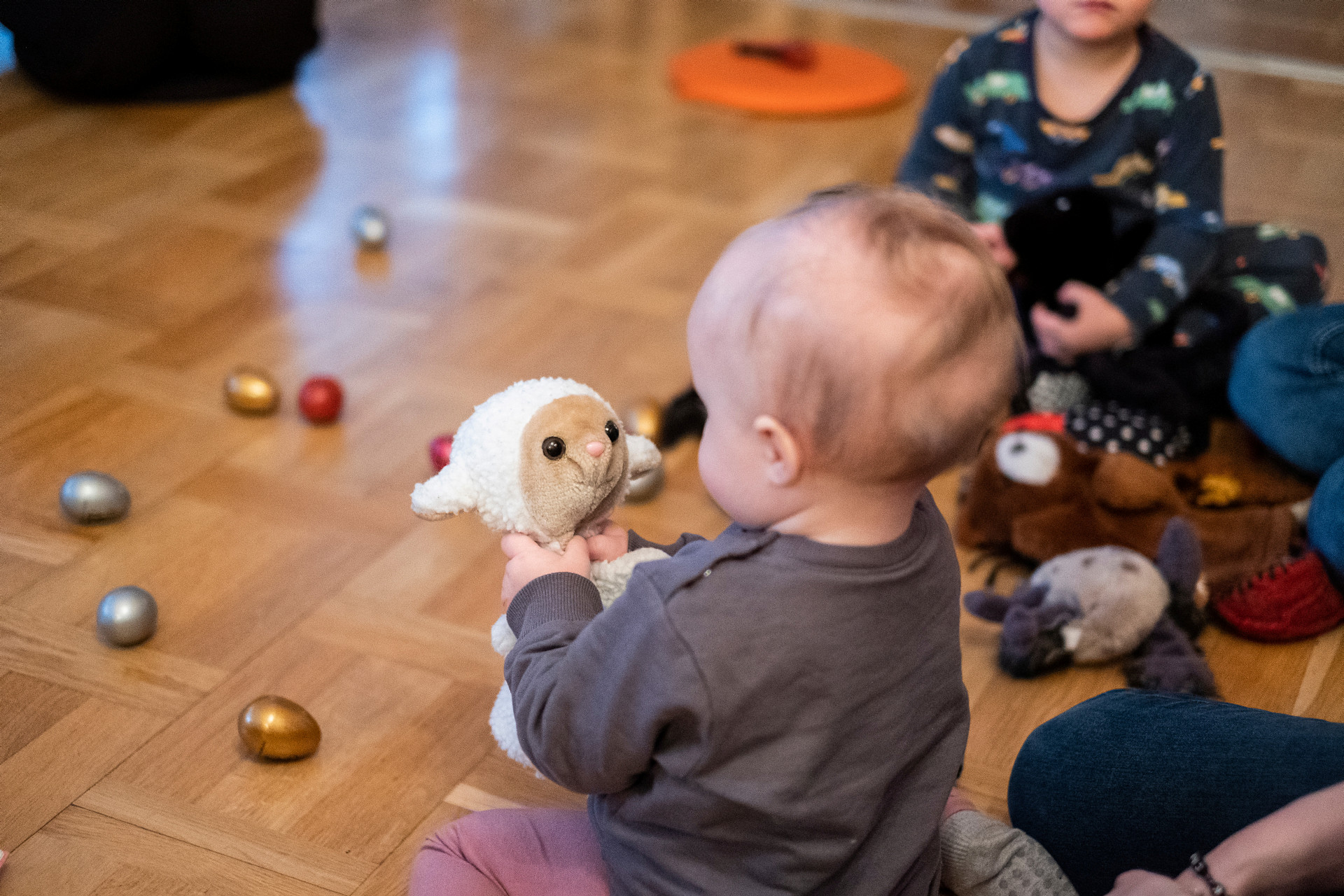 Bebis leker med ett gosedjur på golvet