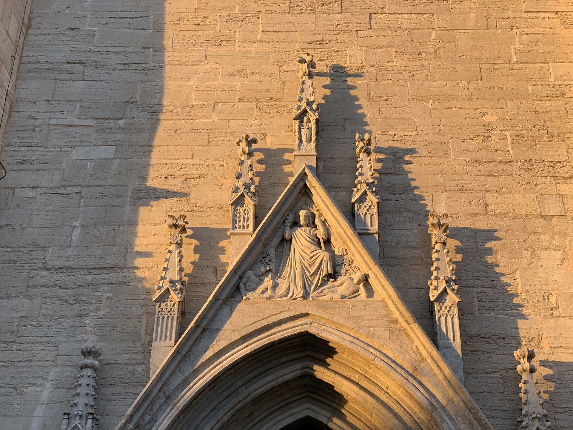 Utsmyckning ovanför en av domkyrkans portar med långa skuggor i den nedgående solen.