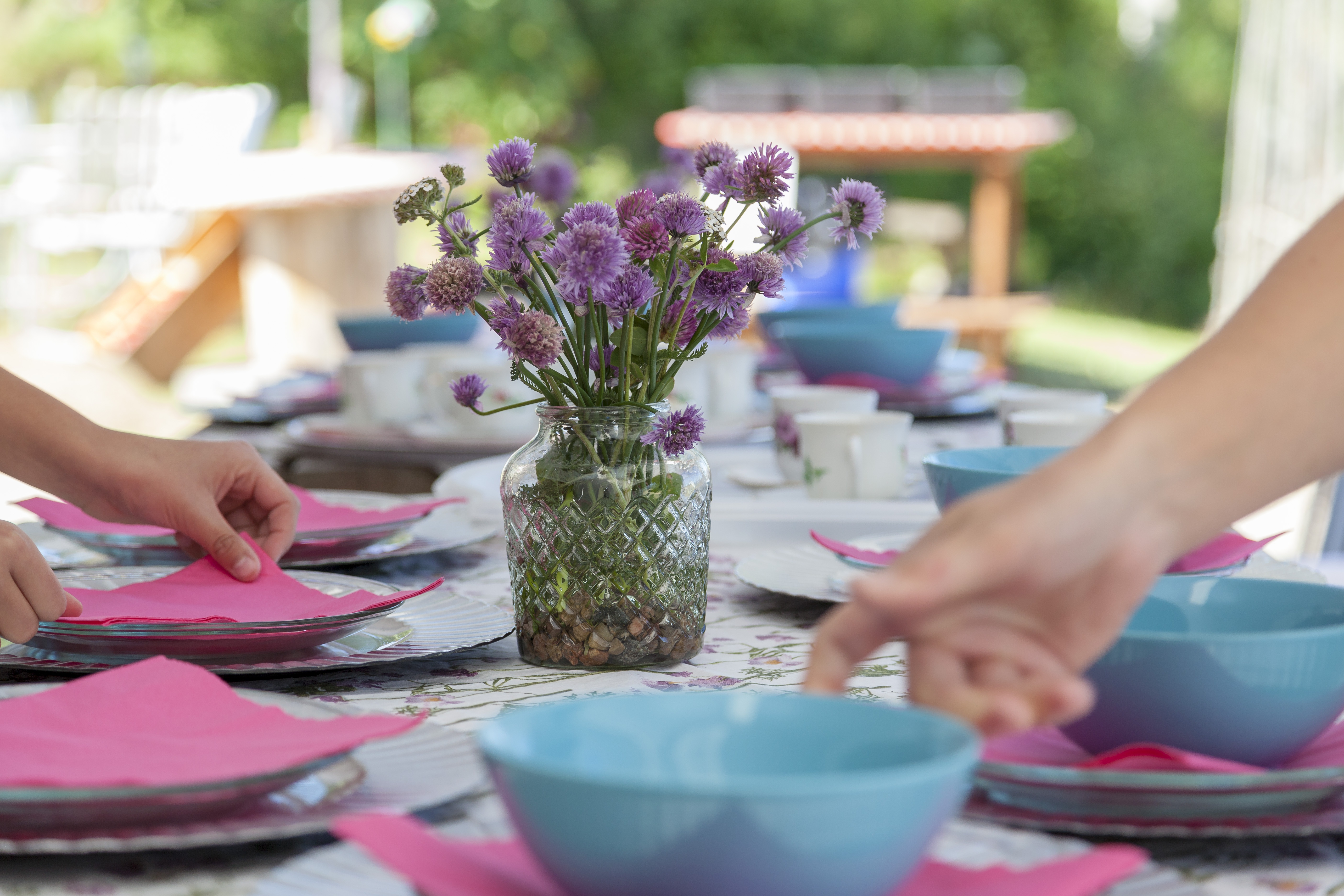 Uppdukat bord med tallrikar och sommarblommor