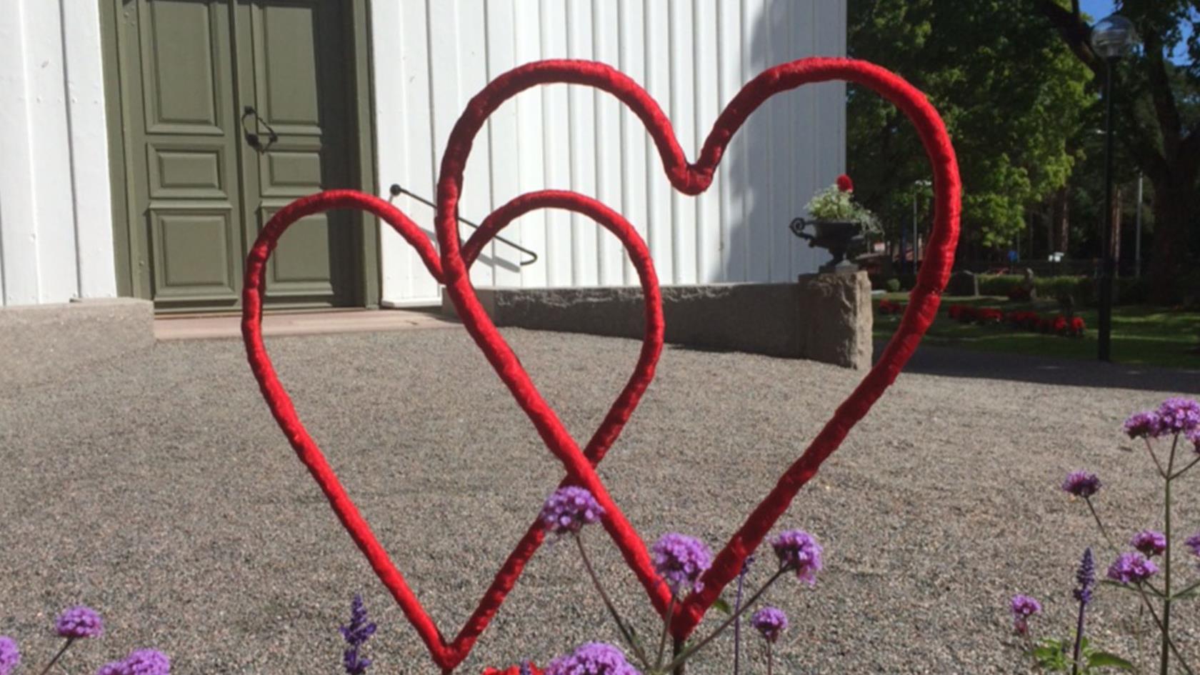 Röda hjärtan i rabatten vid Högbo kyrka.