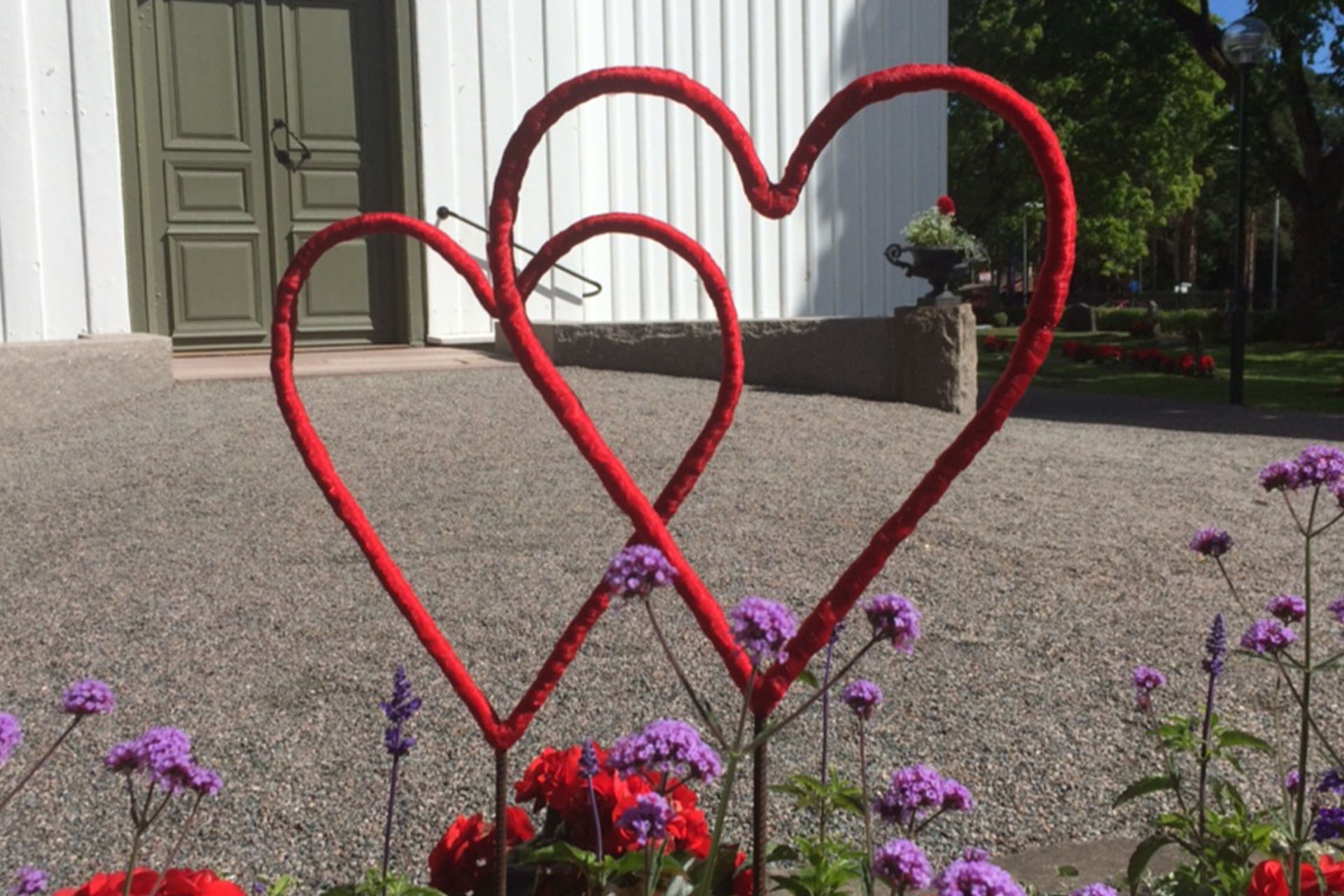 Röda hjärtan i rabatten vid Högbo kyrka.