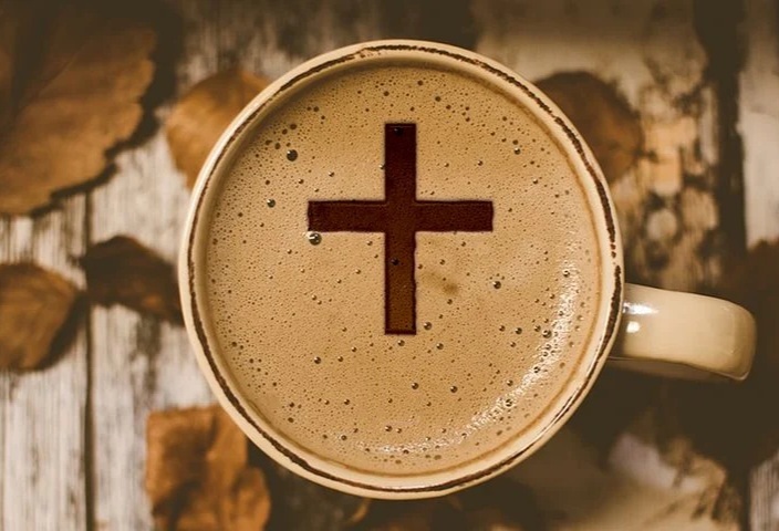 Kaffekopp fotad ovanifrån med skummig yta där ett kors syns.