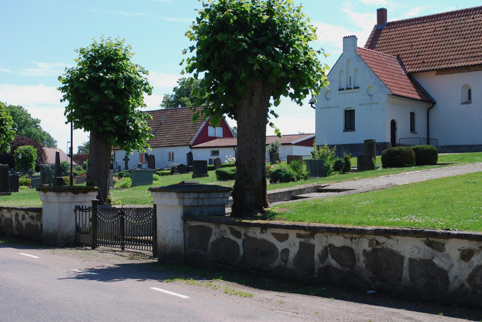 Kyrkogårdsmuren vid Östra Ingelstads kyrka med grinden.