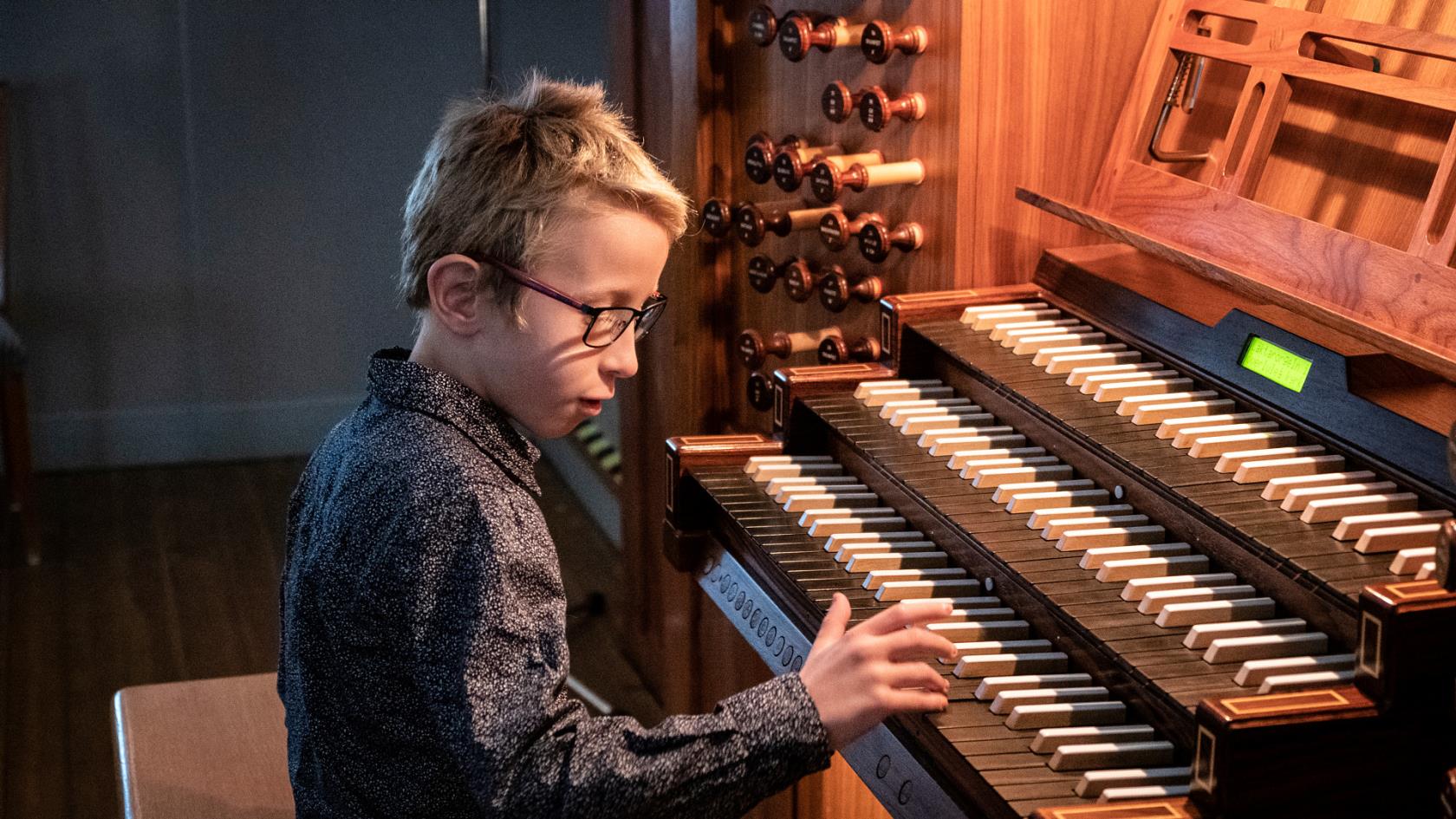 Ett barn klinkar på tangenterna till en orgel.