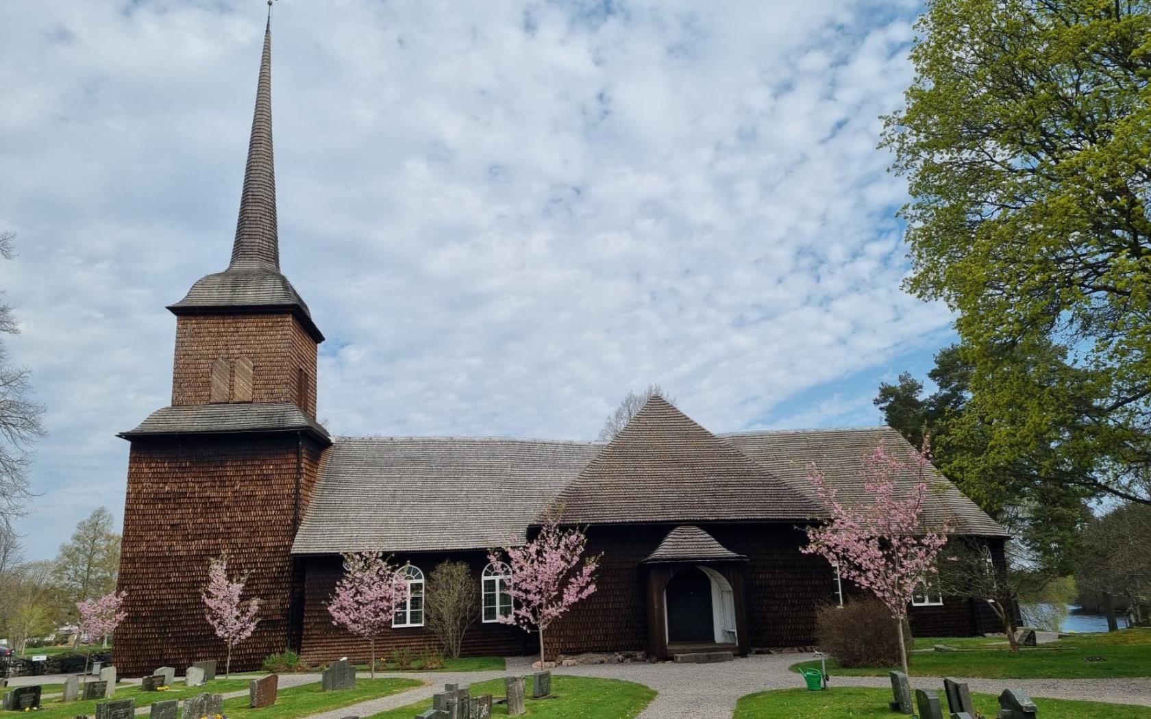 Nysunds kyrka en vårdag med vackra blommande träd framför