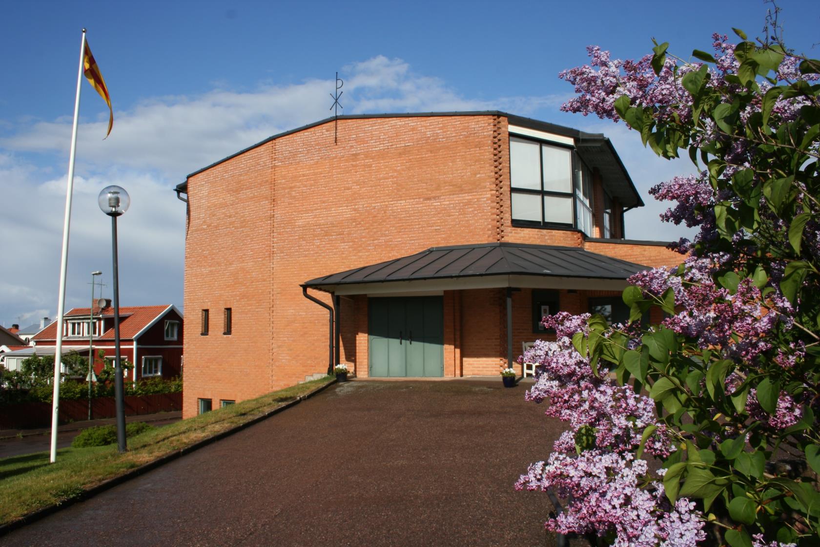 Kyrka med syrénblom i förgrunden