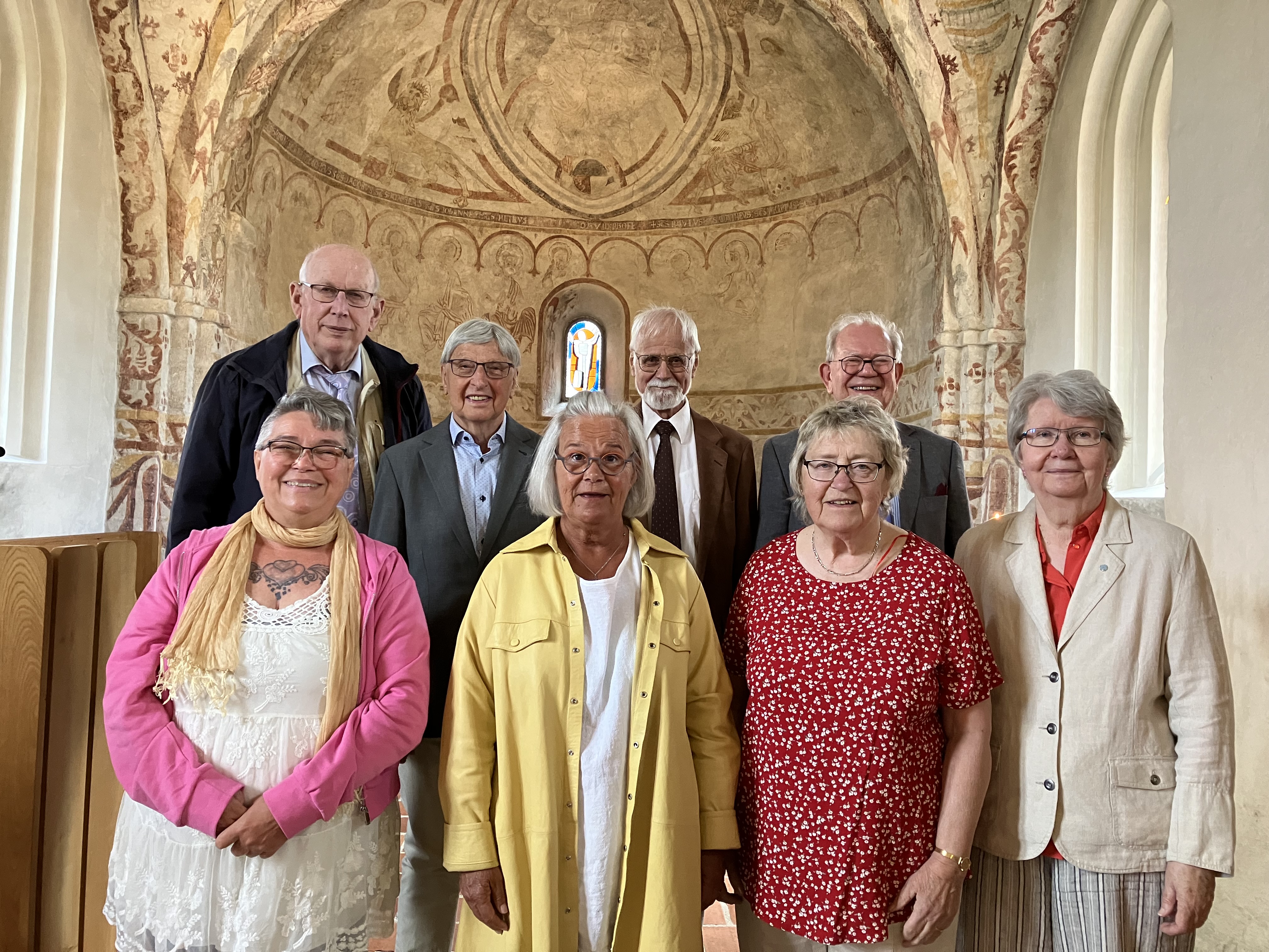 Kvinnor och män i somriga kläder i koret i Hästveda kyrka.