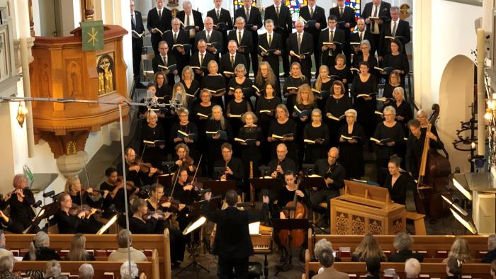 Cirka femtio svartklädda personer står i trappan upp till altaret i Hässleholms kyrka för att sjunga H-mollmässan.