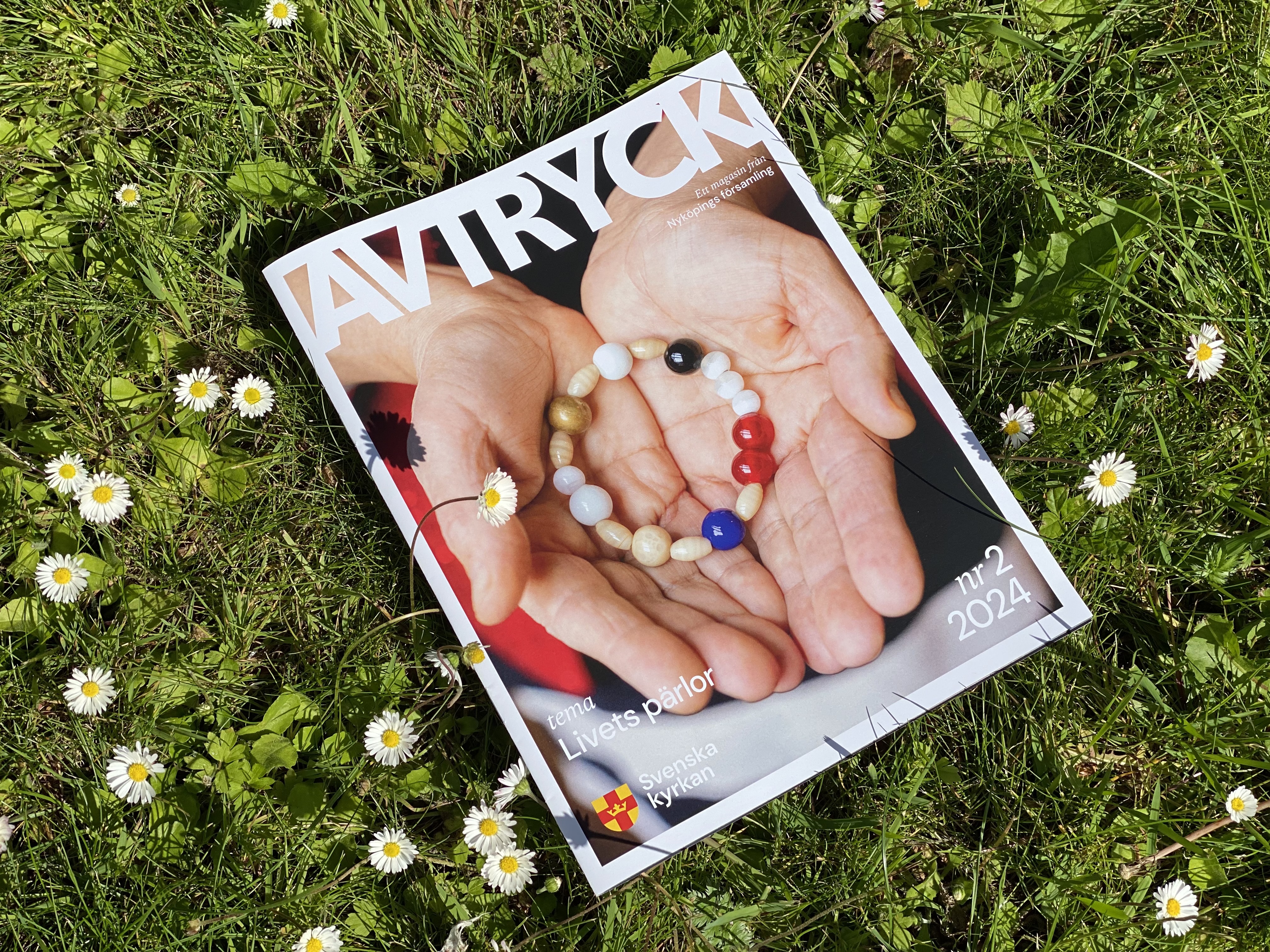 Tidningen Avtryck mot en bakgrund av gräs och vita blommor