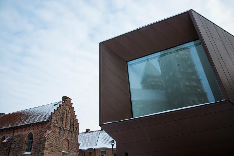 Domkyrkan speglas i fönstret i Domkyrkoforums utkik. Till vänster syns Liberiet.