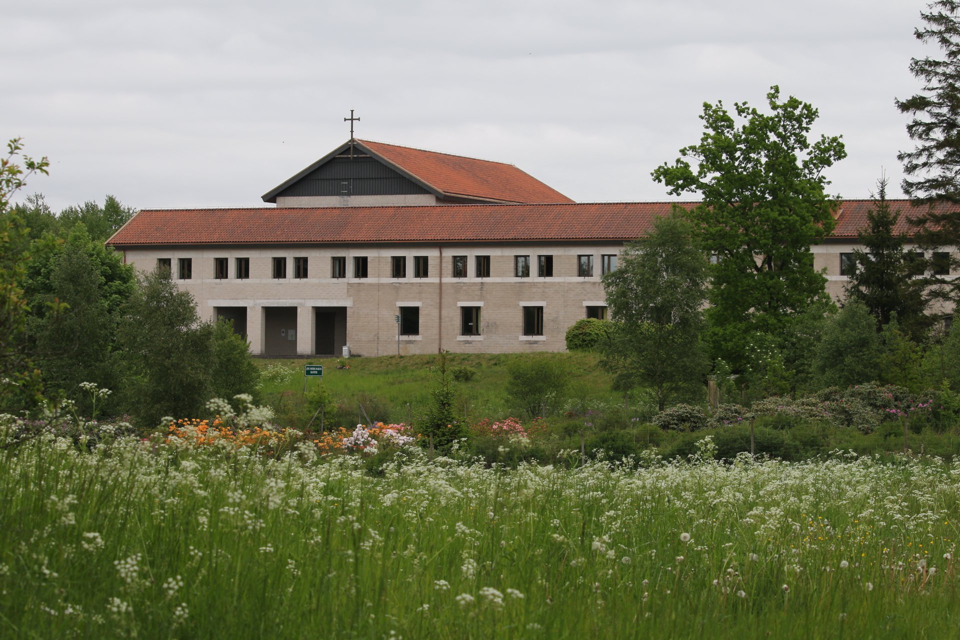 Klosterbyggnad i beige tegel med rött tak.