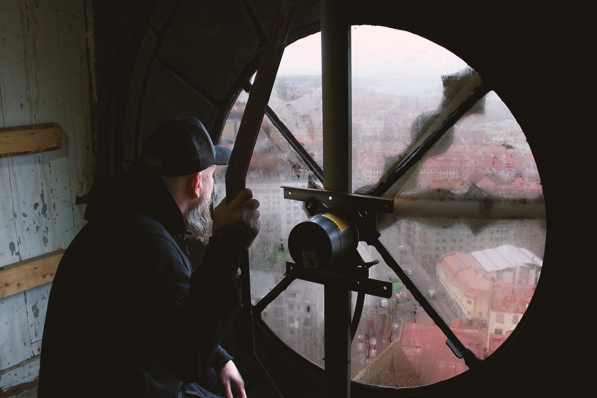 Vaktmästare Joakim tittar ut över Göteborg genom glaset i urtavlan i Masthuggskyrkans klocktorn.