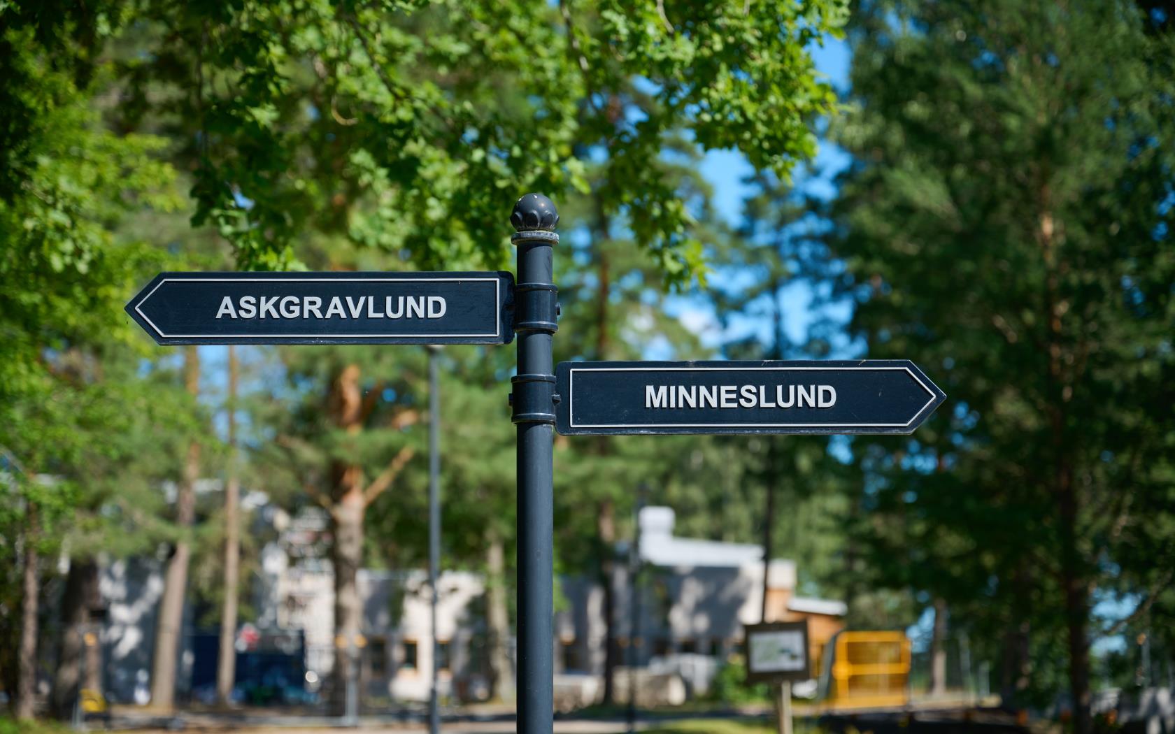 Skylt på kyrkogård, pekar mot askgravlund och minneslund