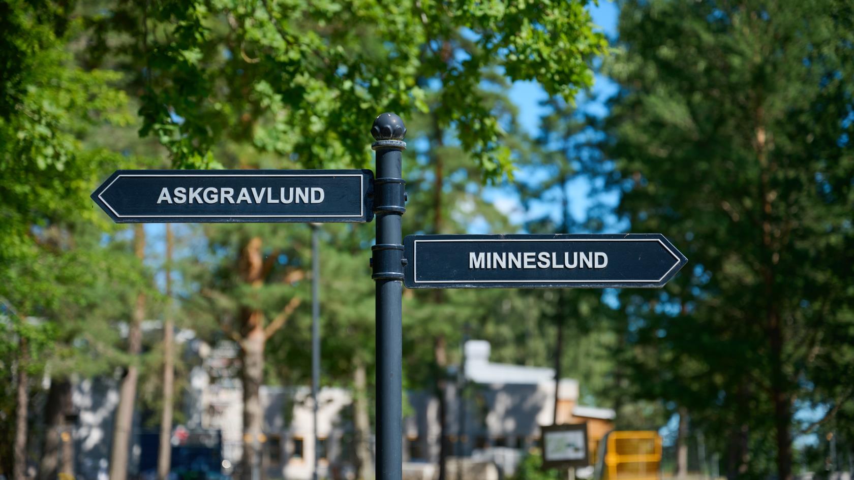 Skylt på kyrkogård, pekar mot askgravlund och minneslund