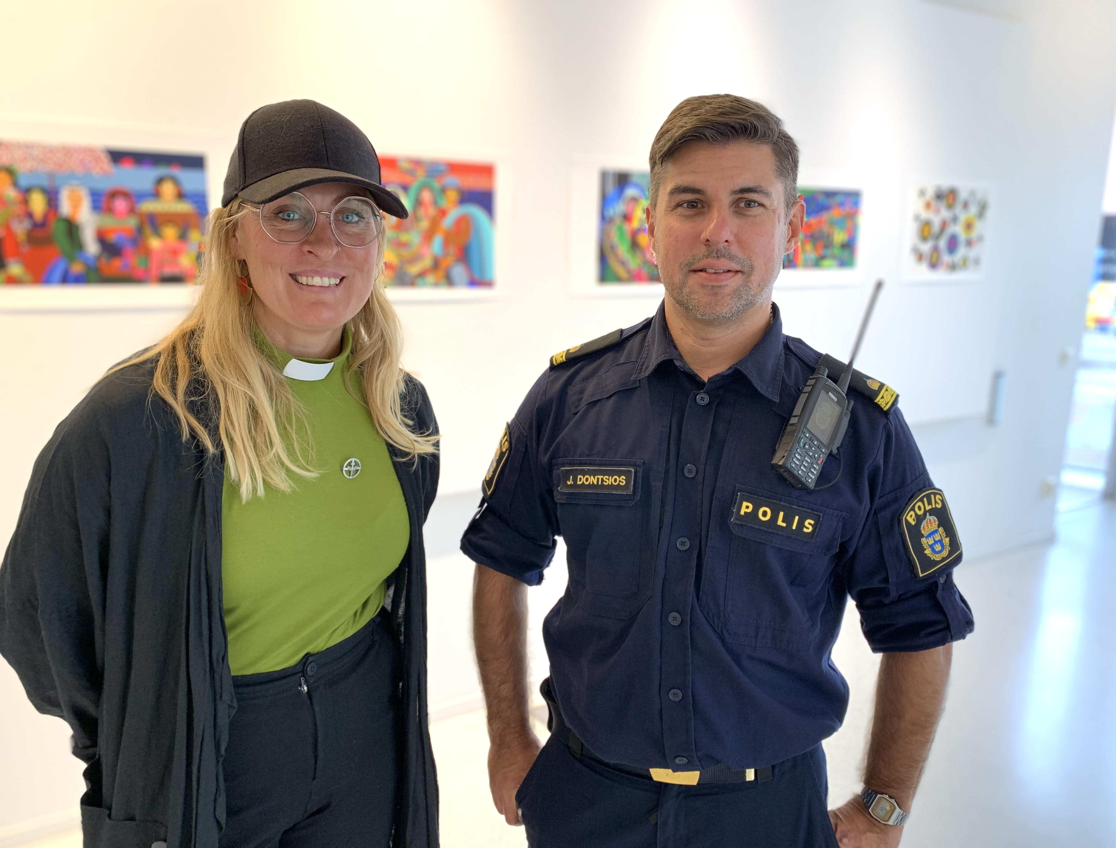 Kvinna med ljust hår och glasögon och en polis med uniform.