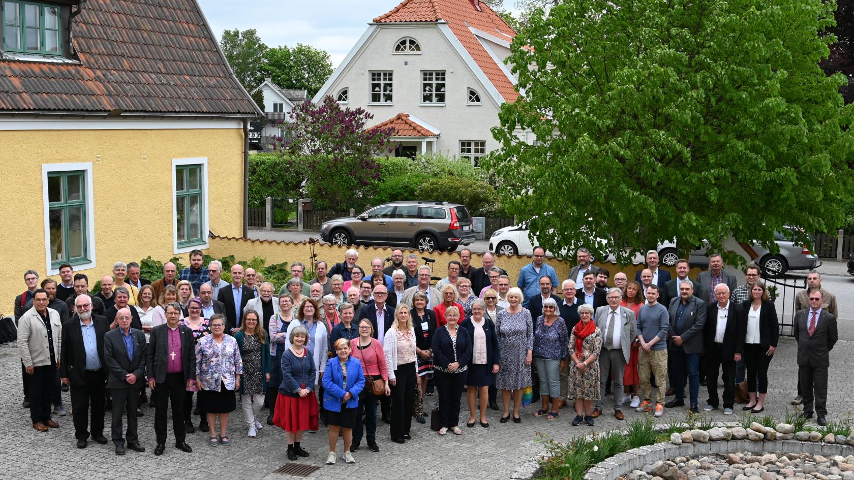 Människor framför ett gult hus