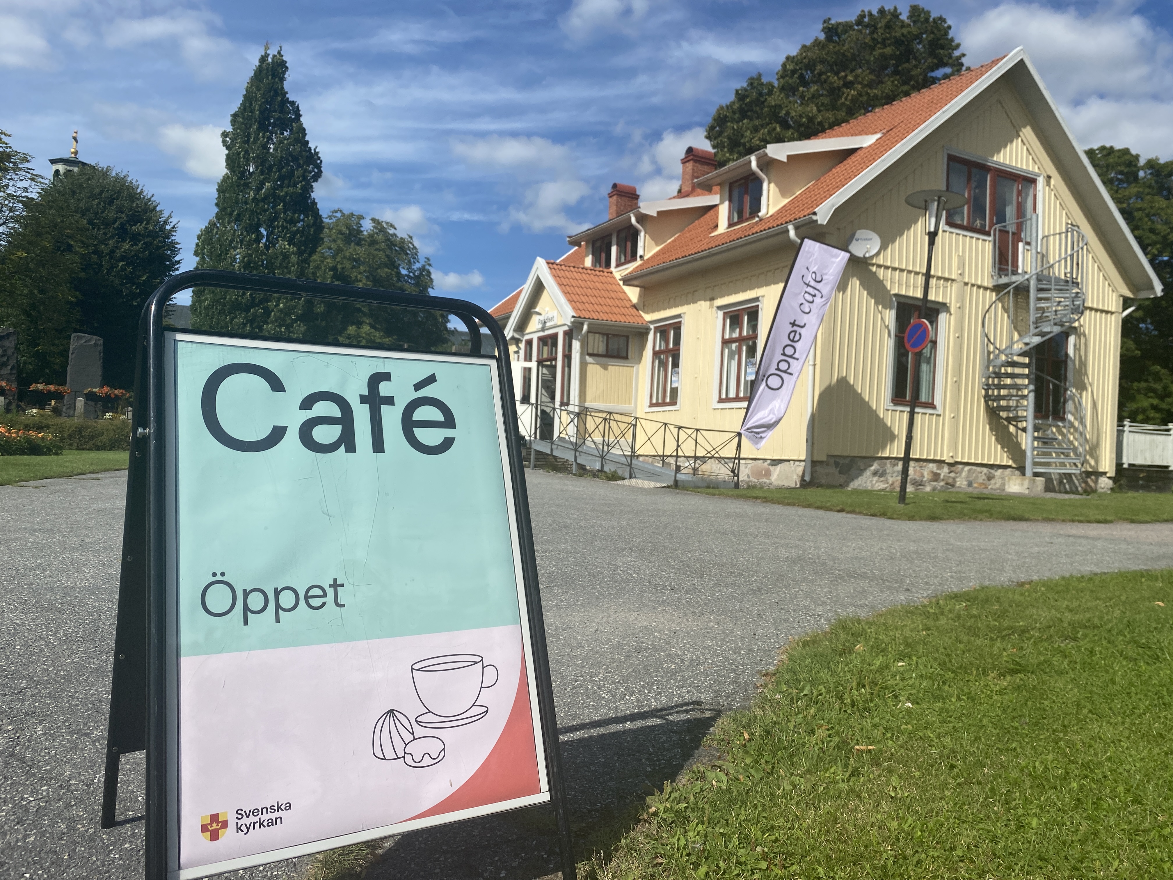 En gatupratare som berättar om öppet café. I bakgrunden syns huset Paradiset.