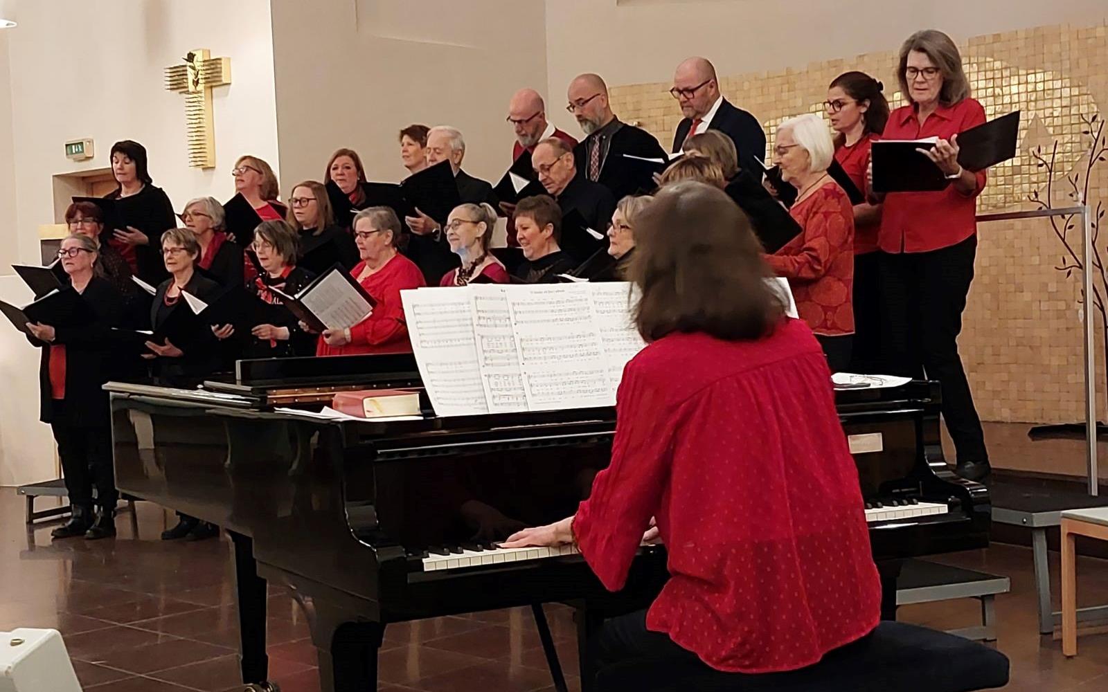 Norrala-Trönö kyrkokör, klädda i rött och svart sjunger i Trönö kyrka.