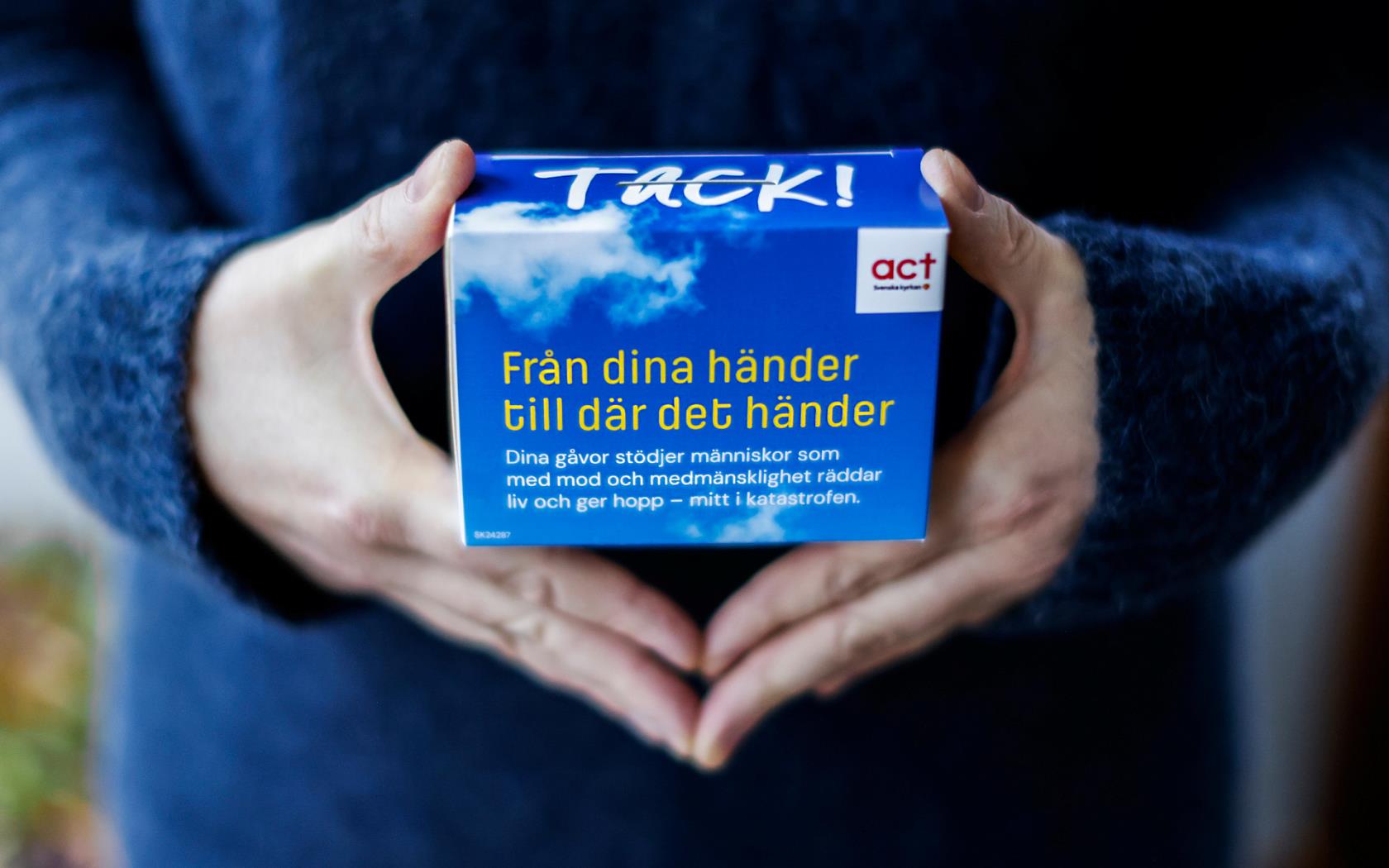 Två händer håller insamlingsbössa.