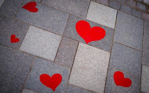 Röda hjärtan på grå gatustenar.
