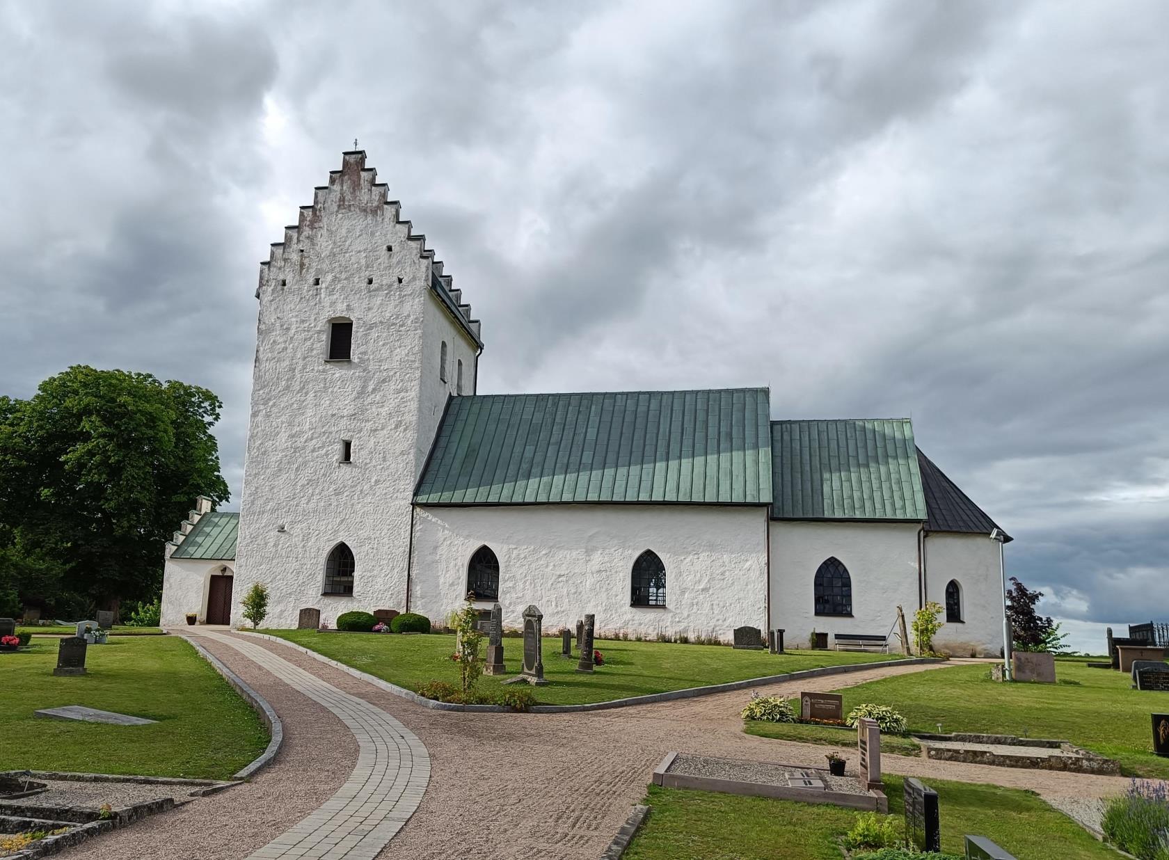 Grusgångar upp mot vit kyrka.