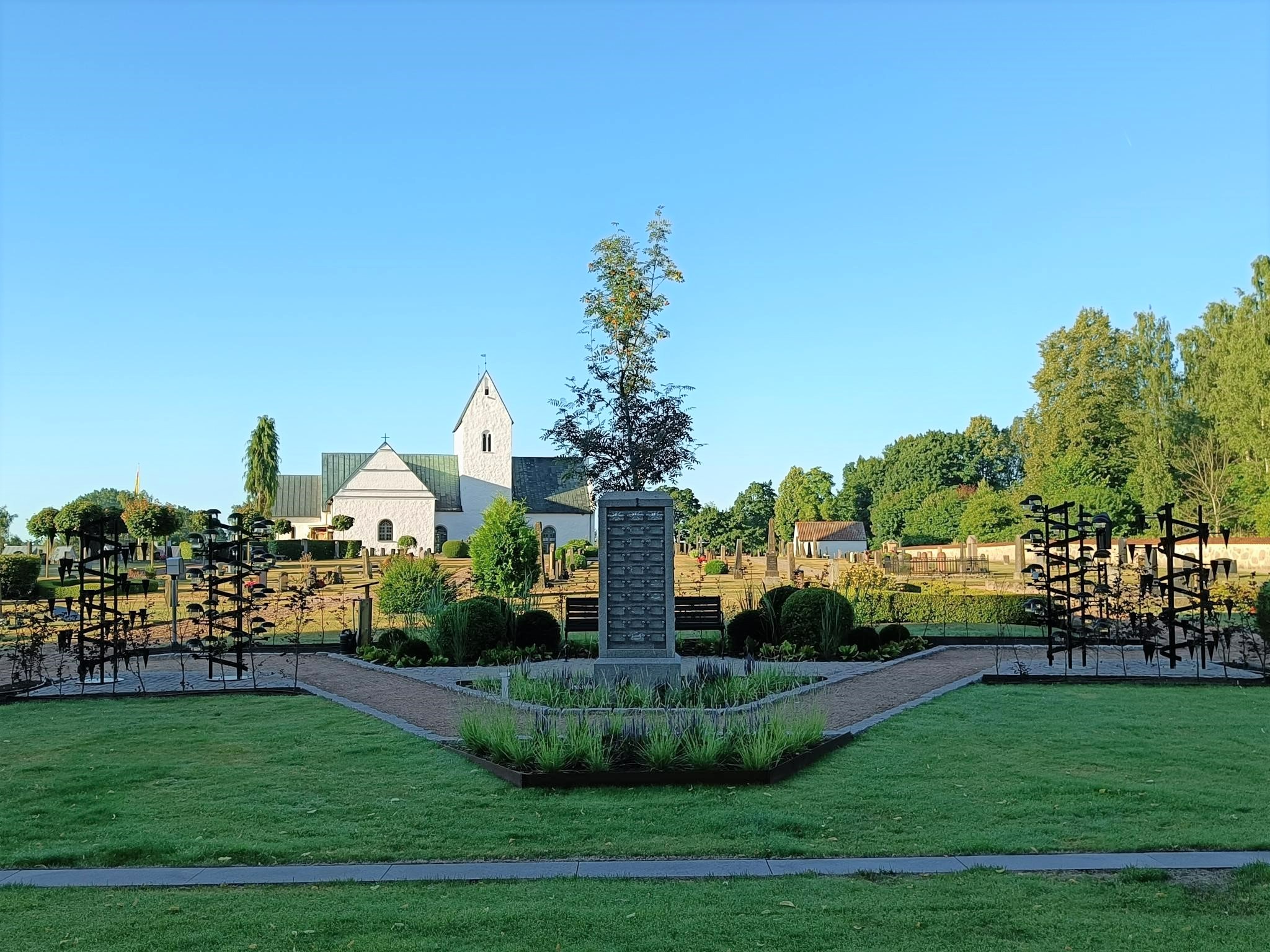 Askgravlund med kyrka i bakgrunden.