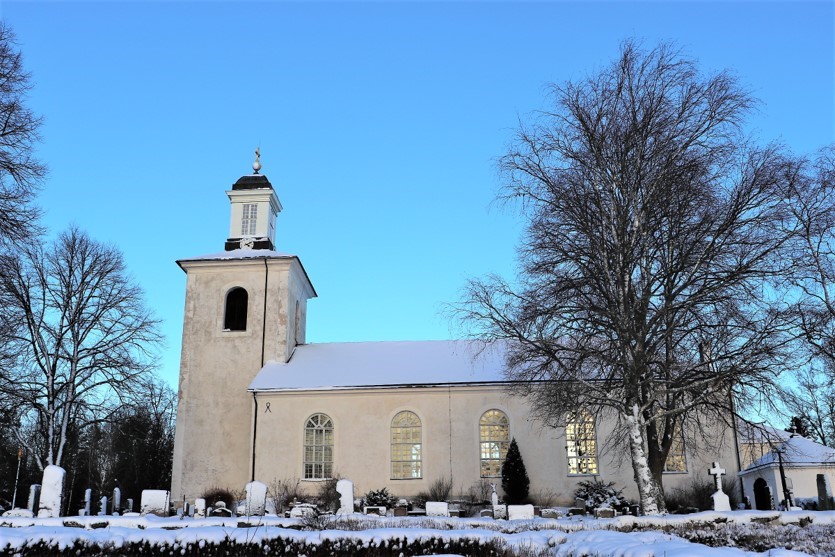 Huddunge kyrka och kyrkogård i snö.