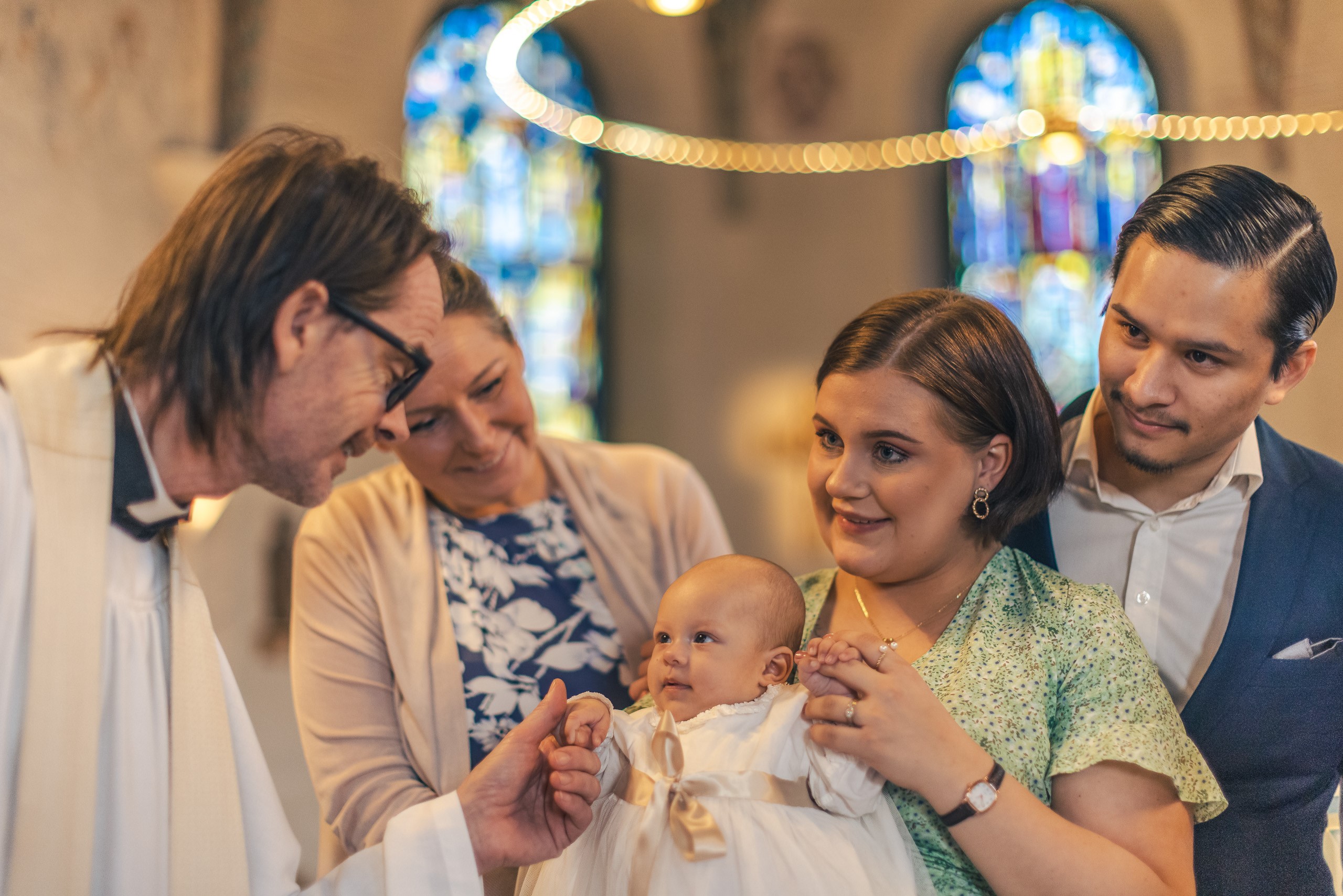 Dopfamilj med präst i kyrkan