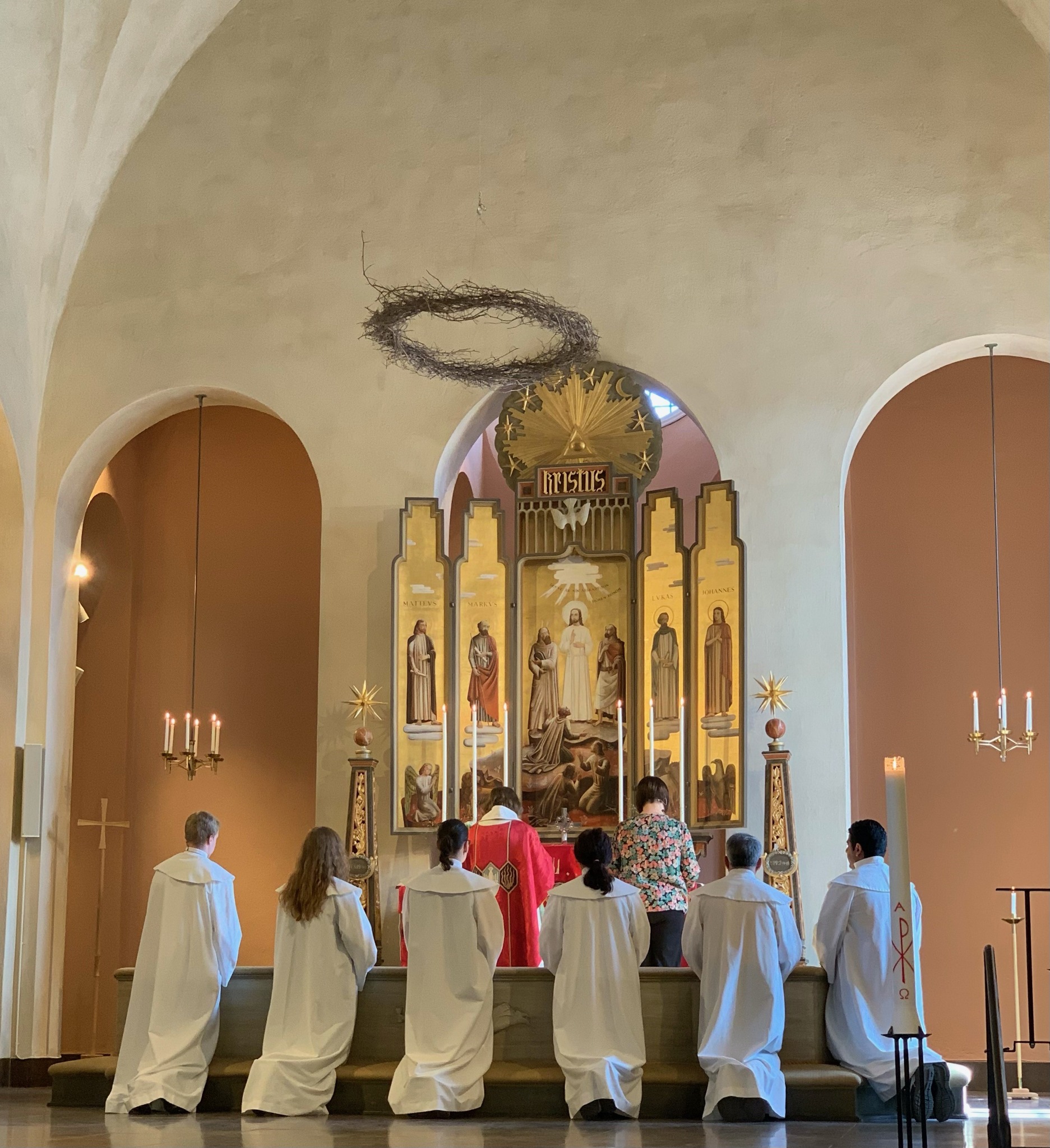 Vuxenkonfirmander knäböjer vid altaret i Staffans kyrka