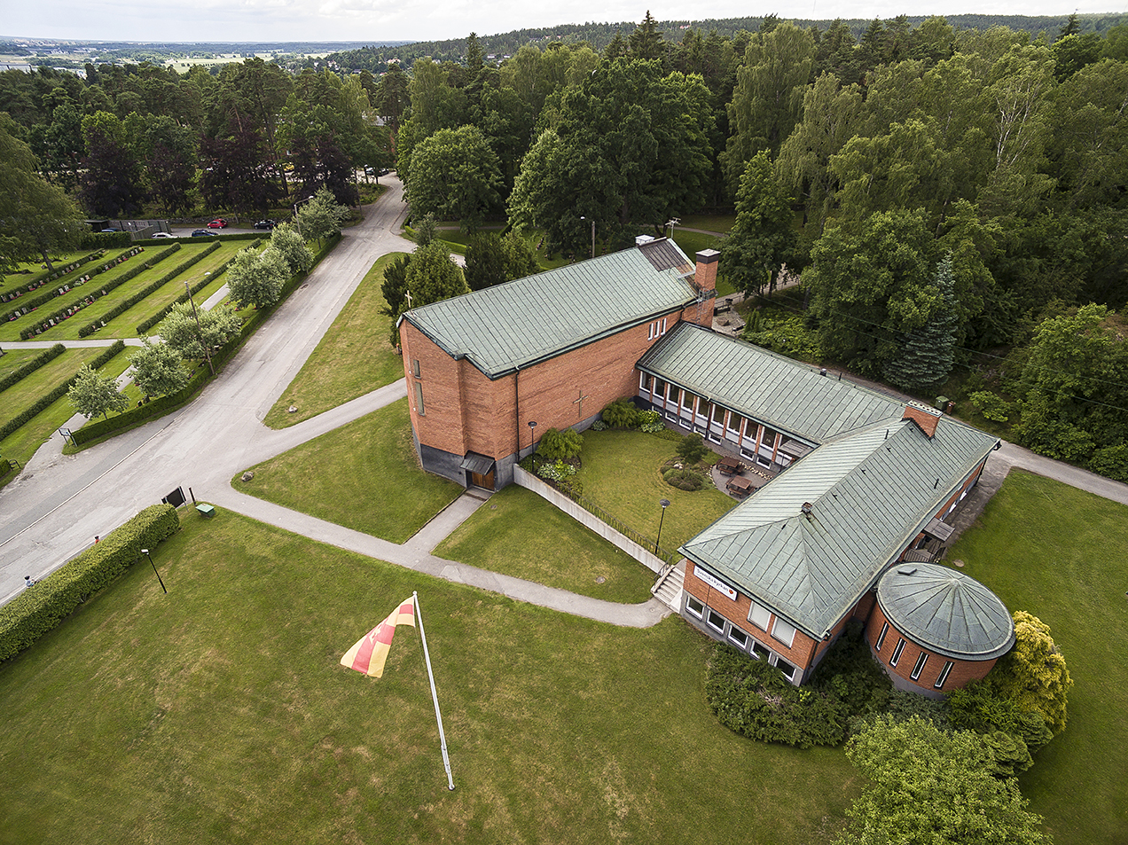 En drönarvy över Ättetorpskyrkan och en del grönområde.