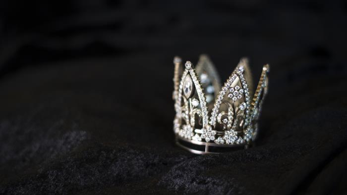 I en sammetsask ligger en liten krona i silver. Kronan är tätt besatt med bergskristaller och glittrar.