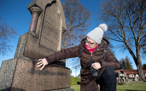 Helen Hagman Olsson framför en gravsten