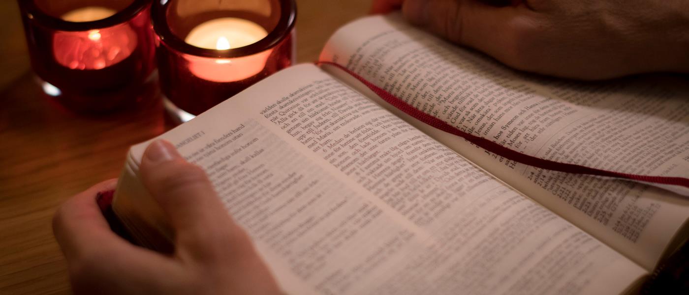 En uppslagen bibel och tända ljus
