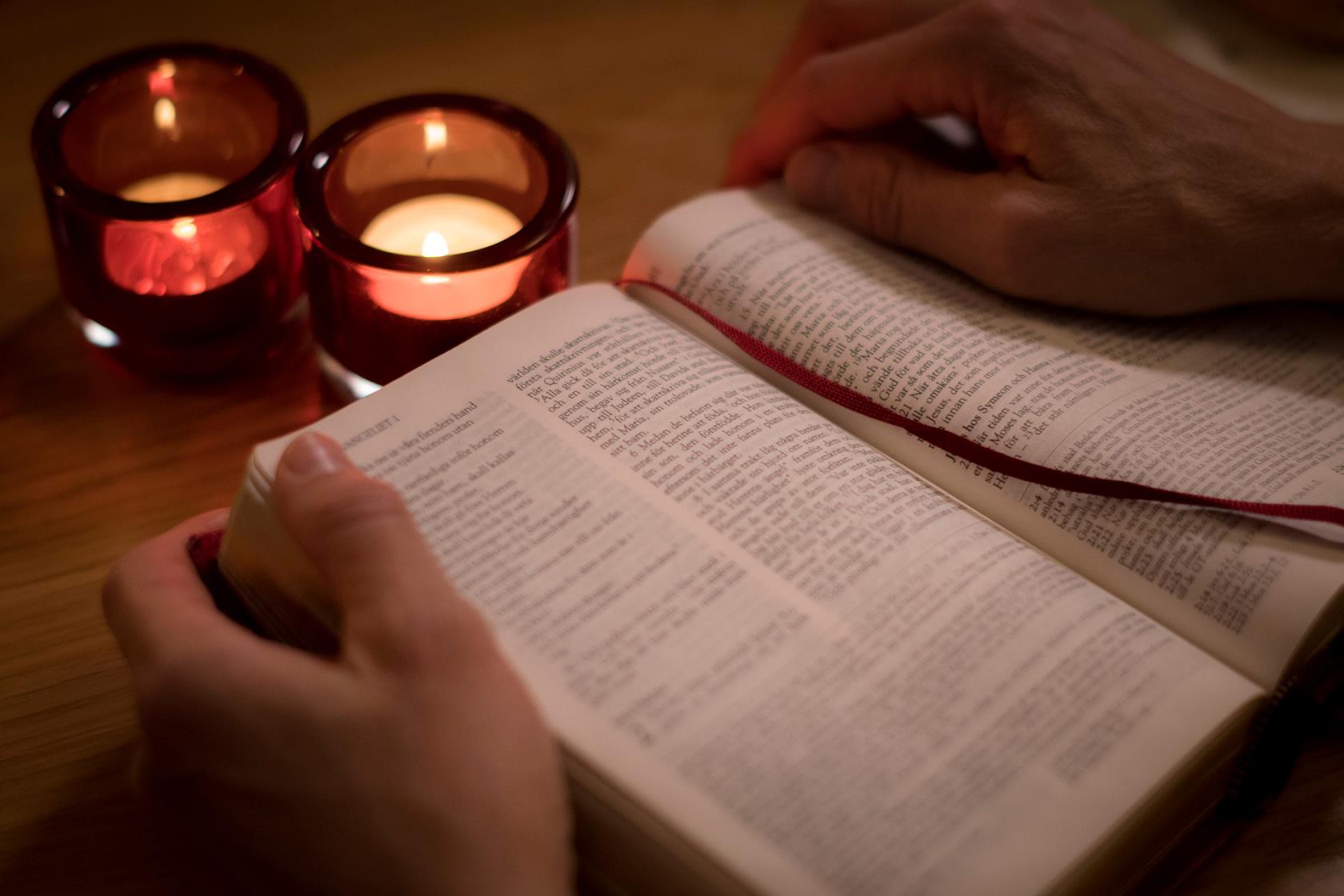 En uppslagen bibel och tända ljus