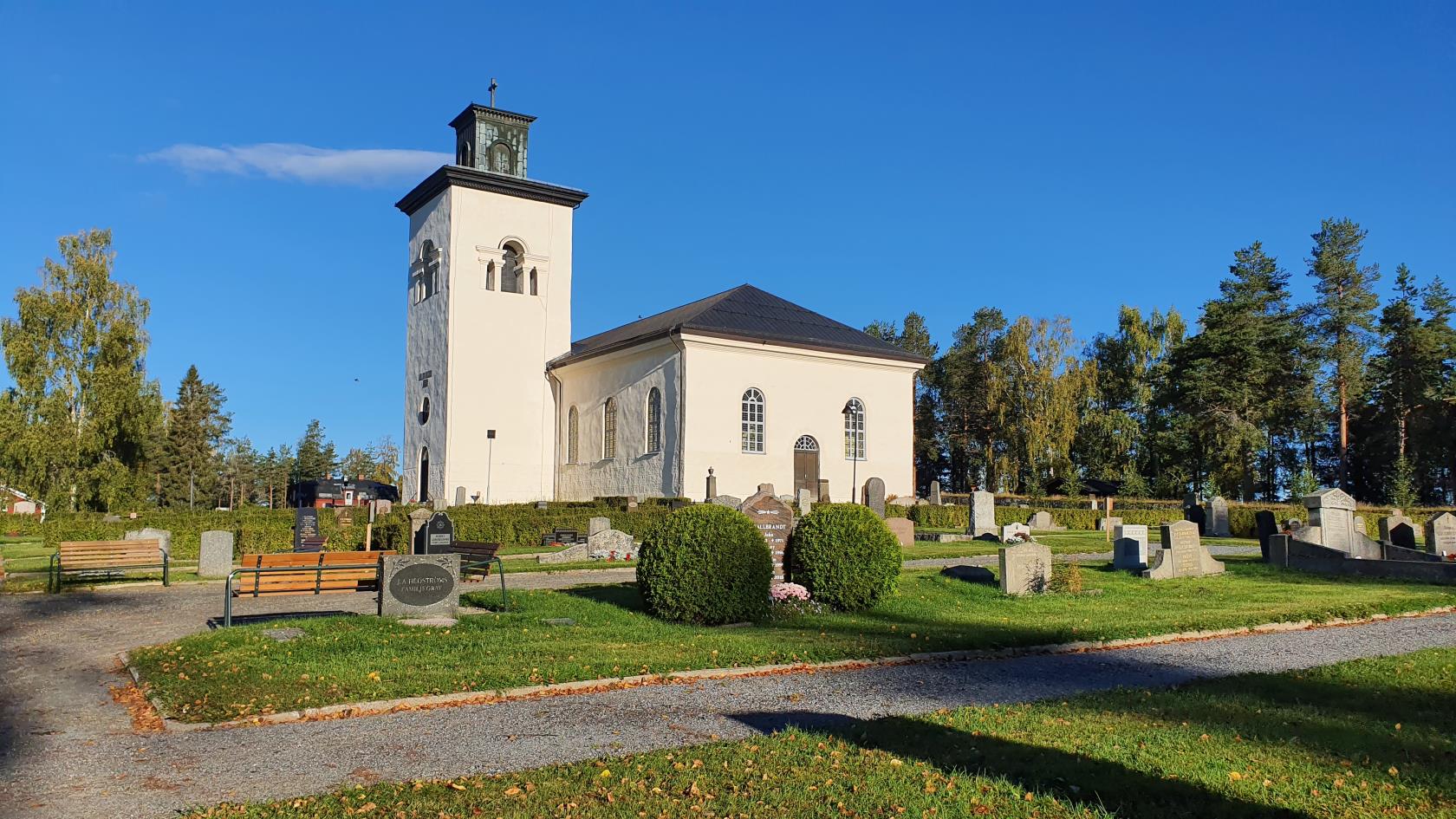 Överluleå kyrka omgiven av den gamla kyrkogården.