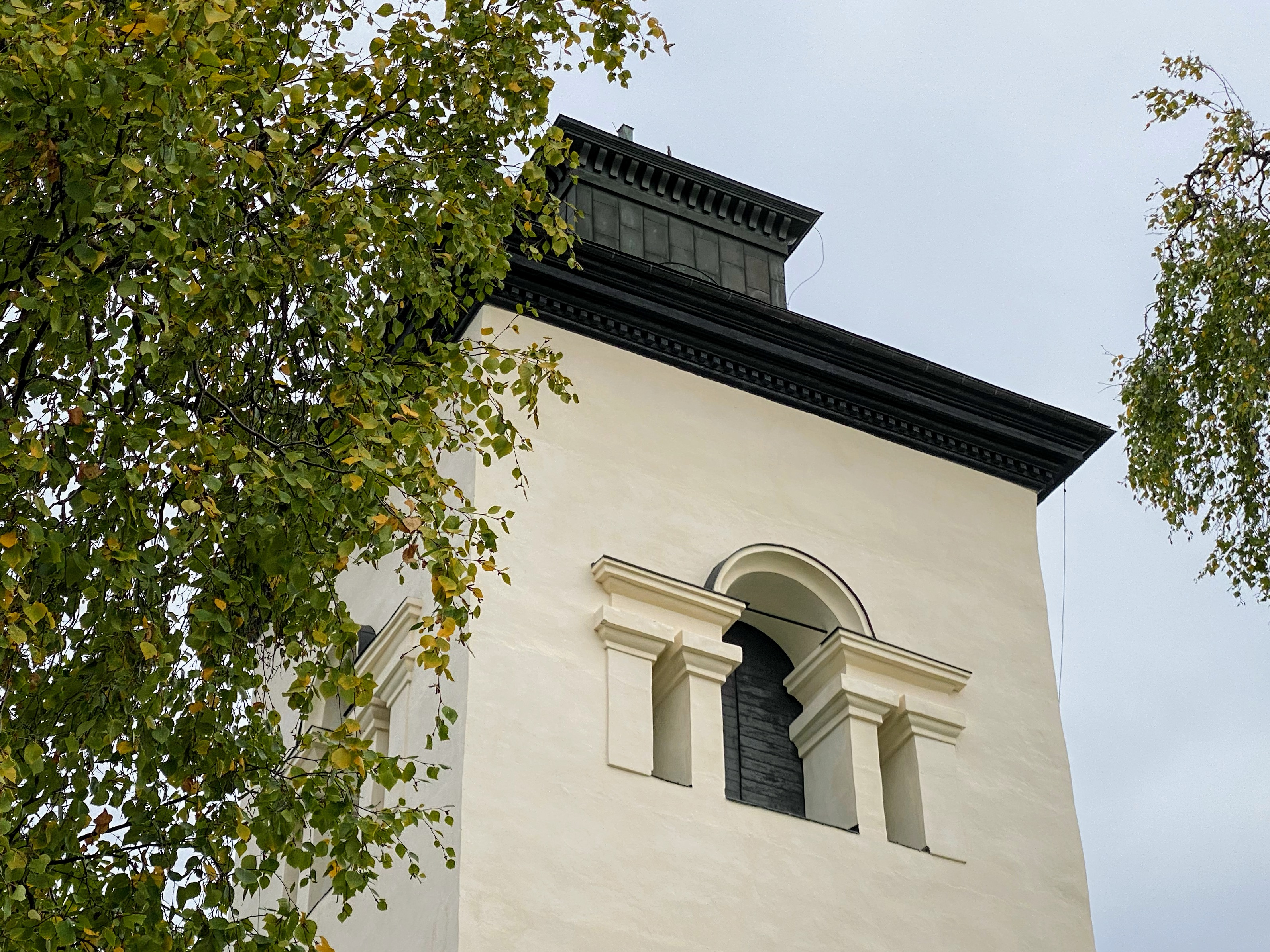 Överluleå kyrkas klocktorn i höstljus. 