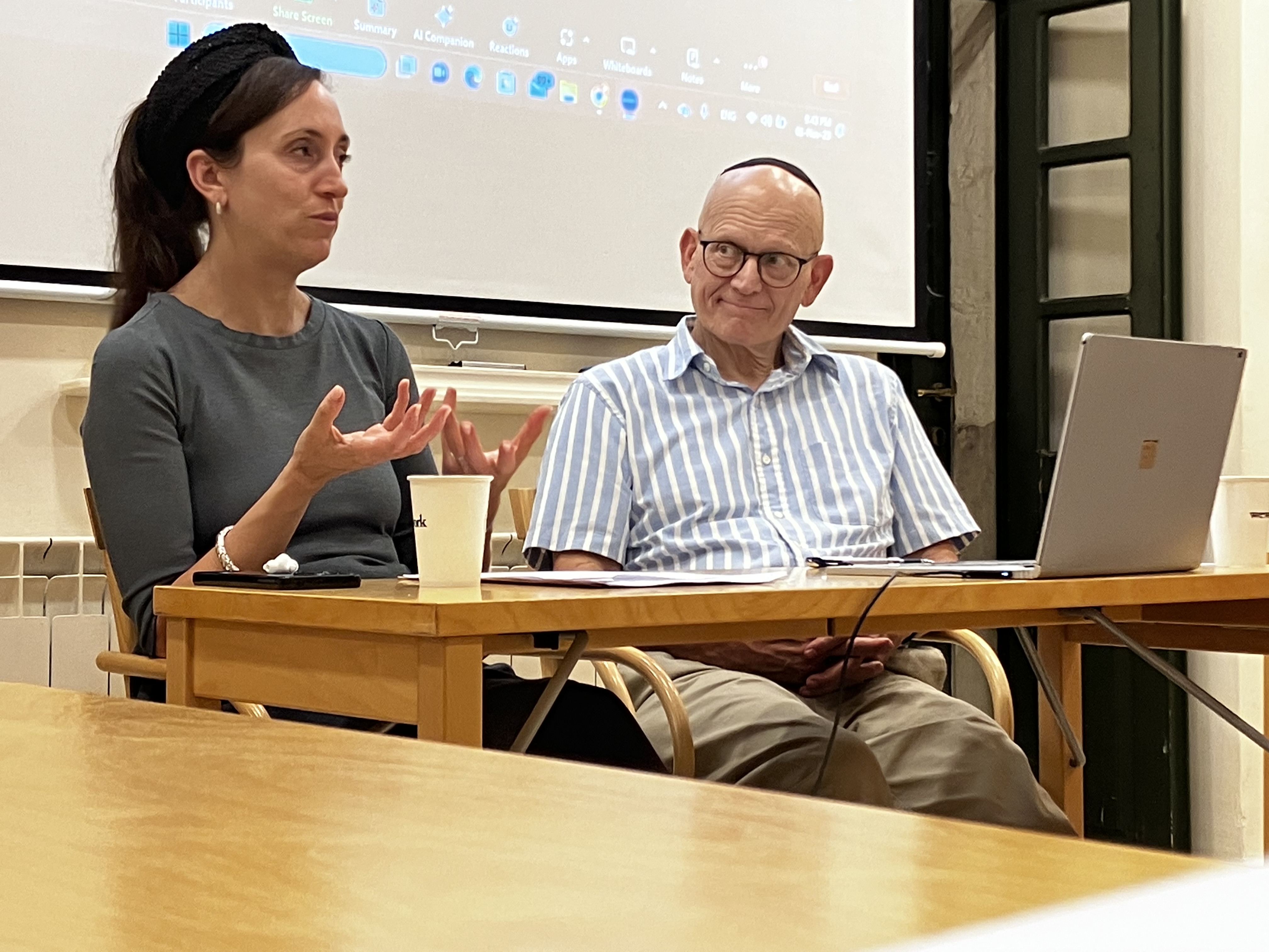 En man och en kvinna sitter vid ett bord i en föreläsningssal.