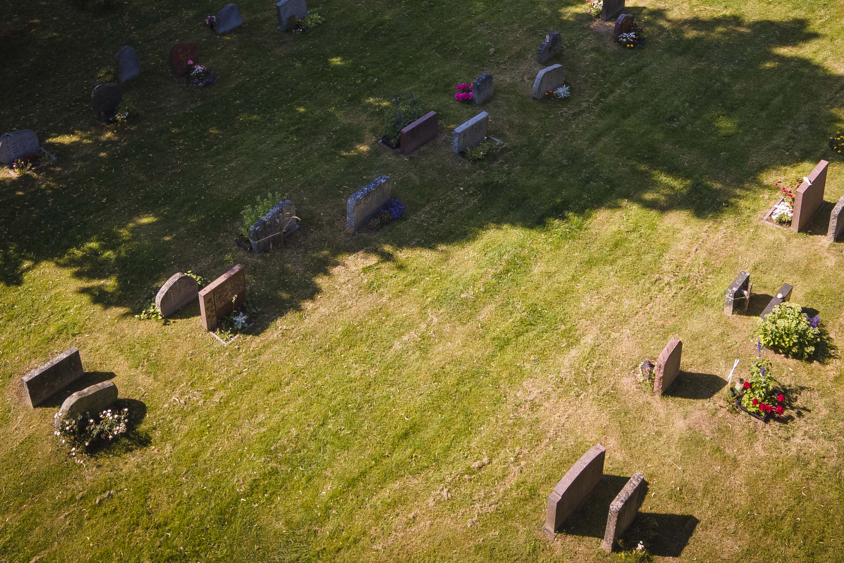 Begravningsplats fotograferad med drönare. Gräset är slitet på sina ställen. 