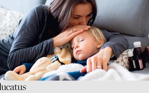 kvinna pussar barn på pannan. barnet ligger i sängen med mediciner runt omkring. 