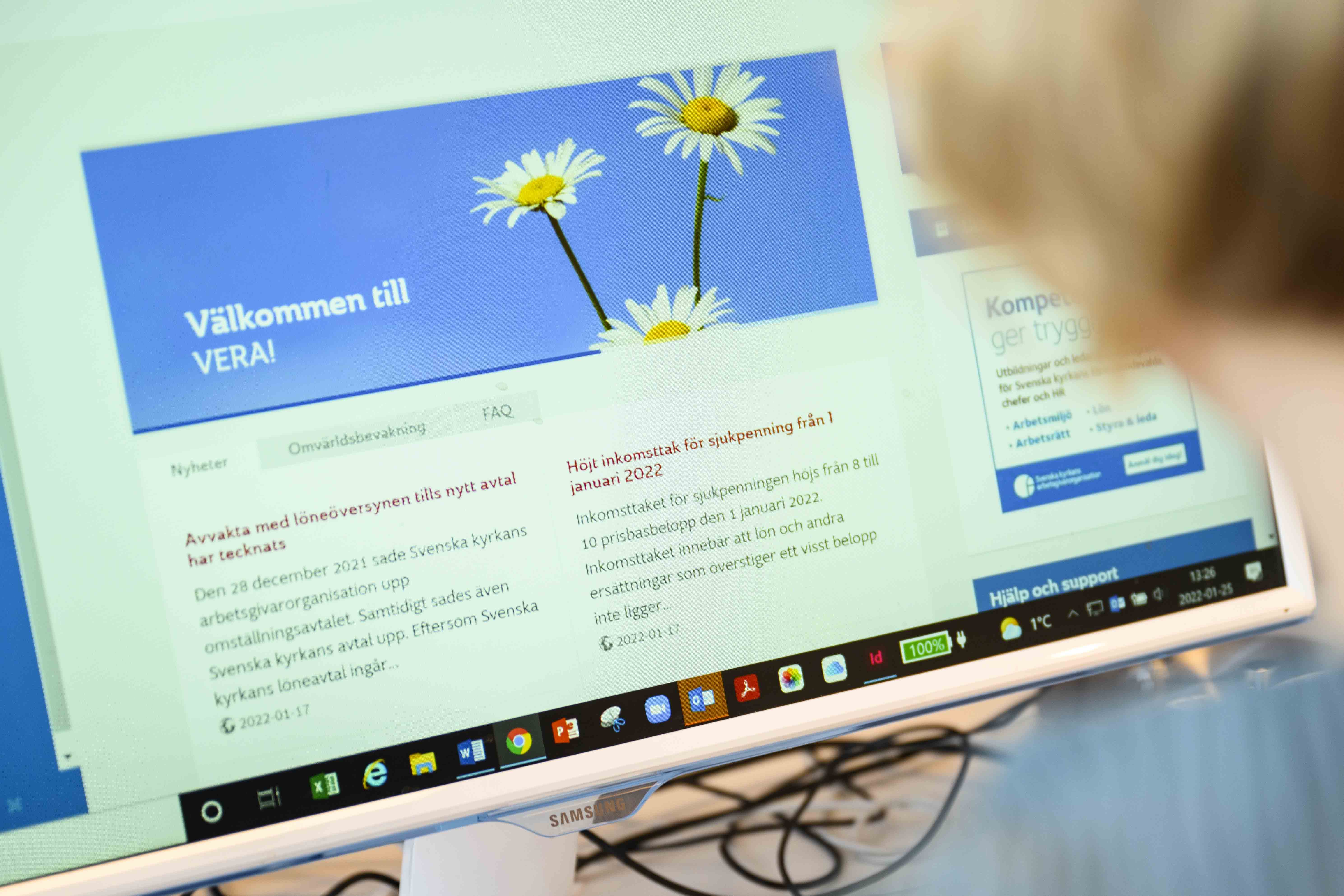 En person sitter vid en datorskärm som visar startsidan till webbhandboken Vera. 