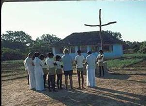 Liten grupp människor samlade utanför en kyrka för morgonbön