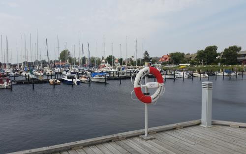 En liten hamn med båtar och en livboj på en stolpe