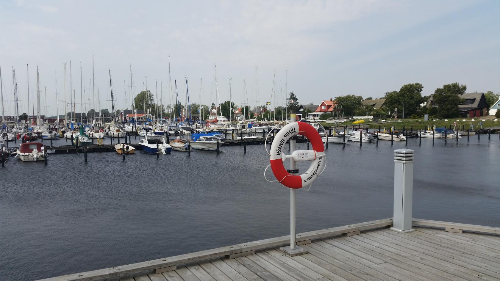 En liten hamn med båtar och en livboj på en stolpe